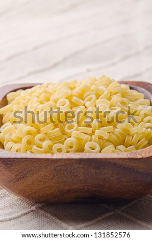Small pasta rings in a wood bowl.