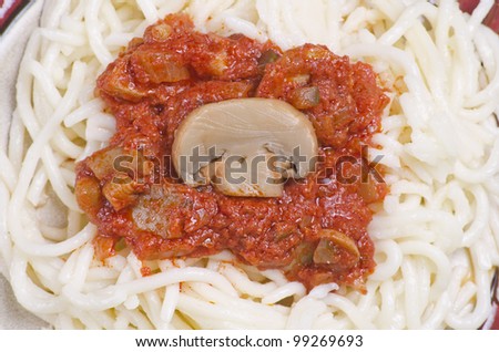 Cooked pasta with tomato sauce and mushrooms.