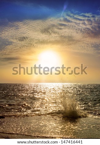 romantic sunset on the Mediterranean Sea, the setting sun illuminates the beautiful clouds and sea wave