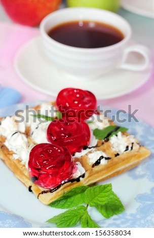 belgian waffles with fruit jelly and fresh mint leaves on blurred background with a cup of coffee