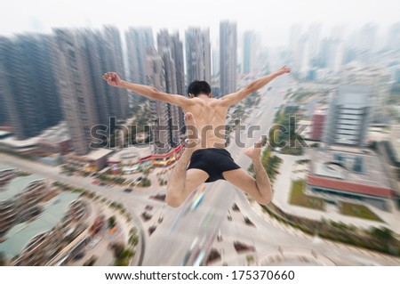 Happy man jumping with cityscape in the background