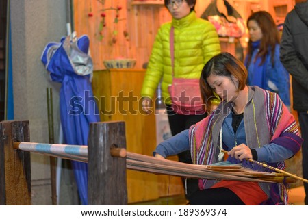 NANNING, CHINA - MARCH 1: Young Female chinese embroidery clothes in front of their shop on 1 March 2013 in Nanning, China.
