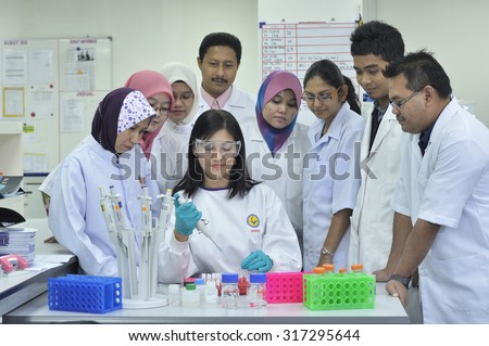 KUALA LUMPUR, MALAYSIA -JUNE 14: Laboratory personnel testing and checking  specimens at Lab Department on JUNE 14, 2012 in Kuala lumpur.