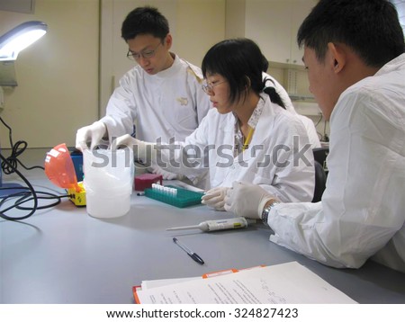 KUALA LUMPUR, MALAYSIA -JUNE 14: Laboratory personnel testing and checking specimens at Lab Department on JUNE 14, 2012 in Kuala lumpur.