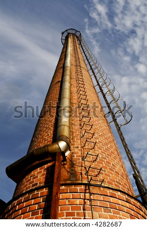 old factory chimney made of bricks reaches for the sky