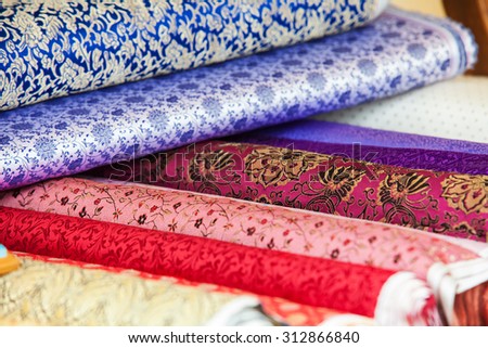 Rolls of fabric and textiles in a factory shop. Multi different colors and patterns on the market