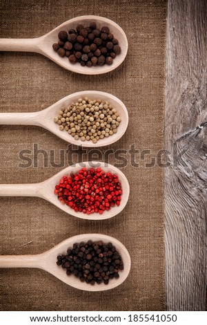 Fresh black, white, pink pepper into a wooden spoons
