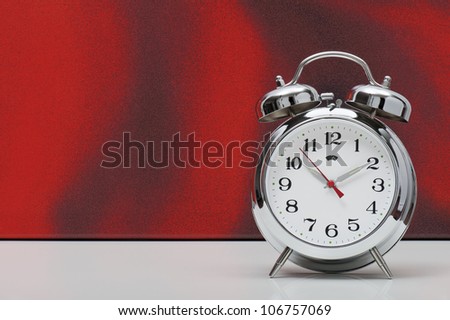classical alarm clock on red background