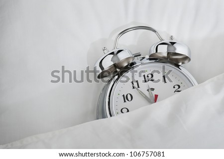 classical alarm clock sleeping on bed until noon
