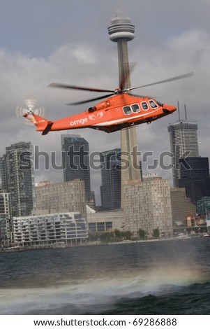 TORONTO, CANADA - SEPTEMBER, 23: New AW139 hovers over the lake Ontario on September 23, 2010 with downtown Toronto in the background. Worth $14milns it was purchased by the ORANGE Air Ambulance.