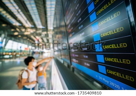 Asian female traveler looking on  flights information board in airport and it show flights cancellation status on because coronavirus or covid-19 pandemic effected. airline business crisis concept Foto stock © 