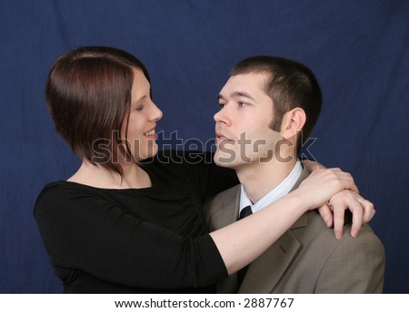 Loving couple looking at each other, her arms are wrapped around him.