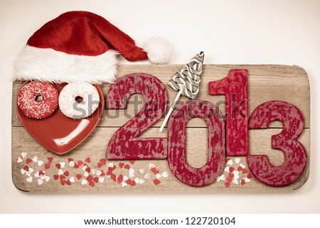 Vintage handmade New Year 2013 snake date with Santa hat on wooden board