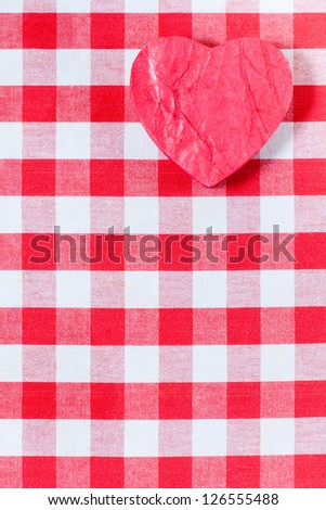 Valentine heart on checkered red and white tablecloth background