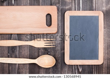 Recipe or menu black board, spoon, fork, plank on wood background