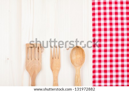 Red and white checkered tablecloth, fork, spoon on white wood background