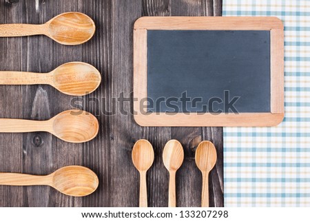 Menu or recipe black board, kitchen tablecloth, spoons on wood background