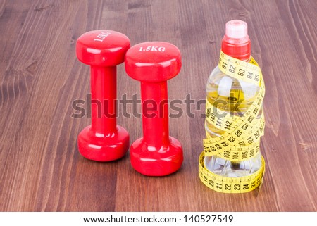 Fitness sport dumbbells, measure tape, bottle of water on wood floor