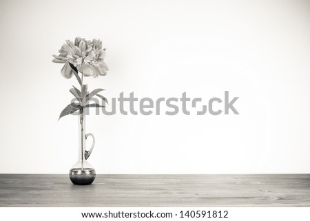 Flower in vase on wooden table sepia photo for vintage background