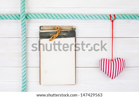 Old notebook and heart on white wood wall background