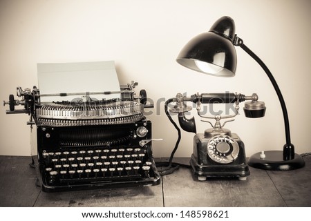 Vintage typewriter, old rotary telephone, table lamp still life