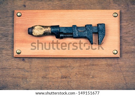 Sign board with old wrench hammer on wood wall background