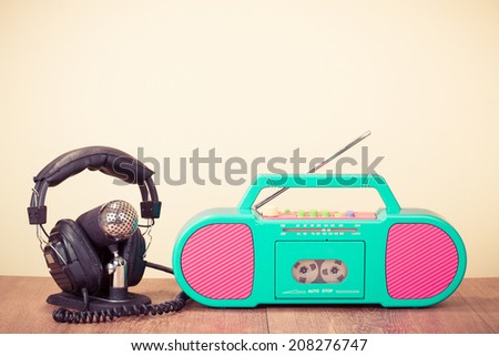 Retro radio cassette recorder, microphone and headphones on table