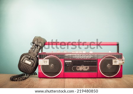 Retro red radio tape recorder and old headphones front gradient background