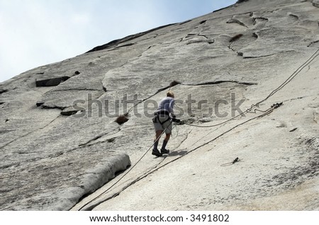 Female climbing Half Dome before the cables are up.