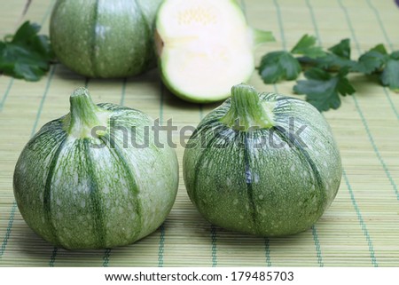Round zucchini on a green bamboo tablecloth