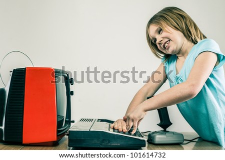 Young child trying to figure out technology confused by typing and old television set