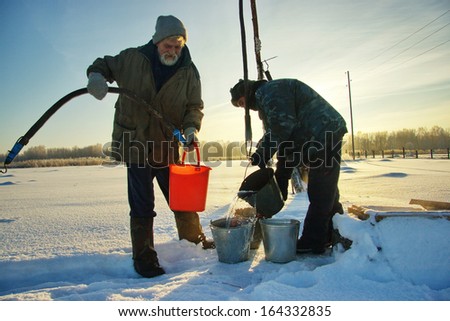 NOVOSIBIRSK REGION, RUSSIA - DECEMBER 21: Men pump water from a well. In this village, people are taking water from a well on the street only, December 21, 2008 in the Novosibirsk Region, Russia