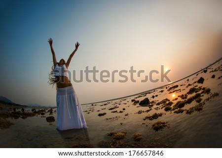 Woman silhouette dancing on the beach