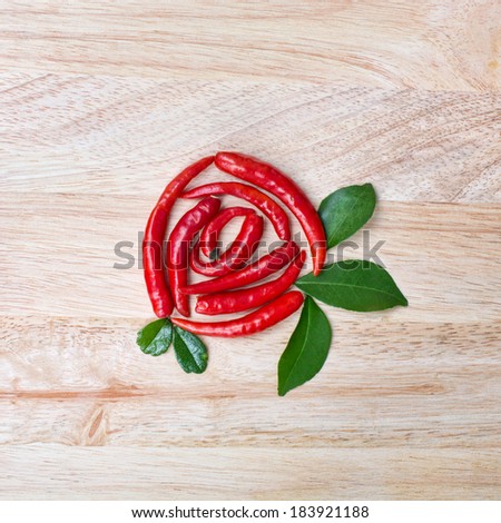 Beautiful sill life composition with chili rose on wooden background