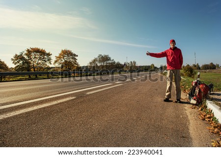 Young Man Hitchhiking on a Road