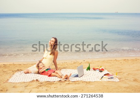 Mother and daughter relax near the sea. Outdoor work and study concept