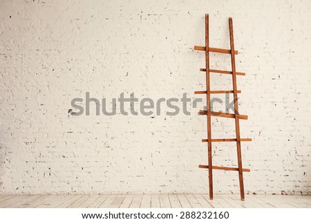 Wooden Ladder near white Brick Wall in empty Room ready for Renovation.