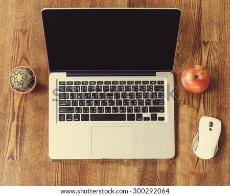 Laptop computer on Wooden Background with Apple Fruit and Cactus Flower. Work place at home
