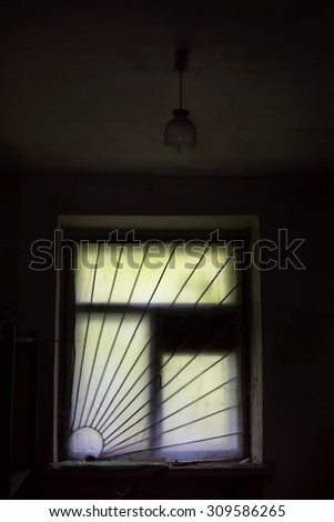 Old muddy window with bars in  dark abandoned room