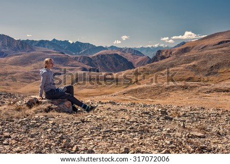 Woman hiker sitting on mountain top, Relax and Enjoy