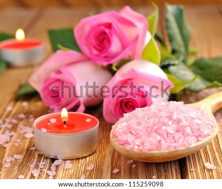 Roses, sea salt and candles on a brown table