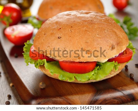 Vegetarian burger with vegetables close-up on a brown table