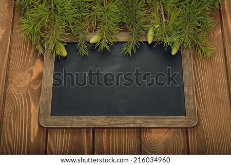 Green twigs and writing board a brown background