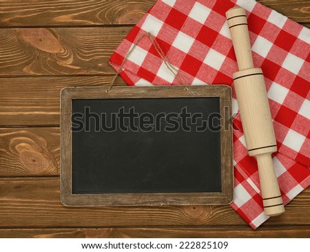 Writing board napkin and rolling pin on brown background