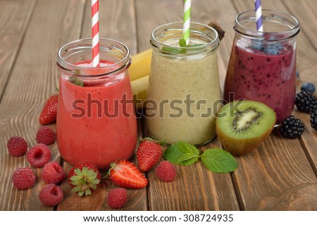 Various berry smoothies on a brown background
