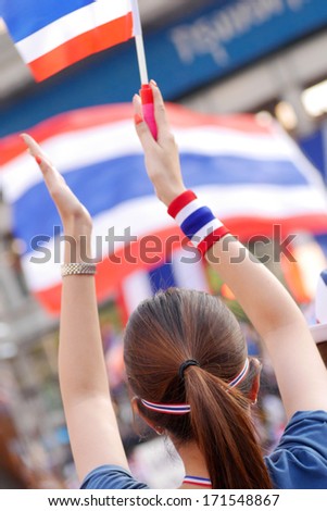 BANGKOK - JAN 13 : An Unidentified protester applauds with Thai flag in an anti-government rally at Asok Montri road (Sukhumvit 21) on January 13, 2014 in Bangkok Thailand.