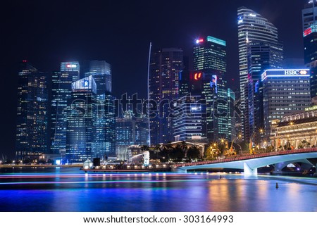 SINGAPORE - JULY 31_Business buildings shining beams of light at night time around Marina Bay on July 31, 2015 in Singapore.