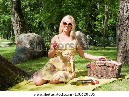 Beautiful young blond woman with picnic crib outdoor