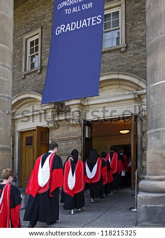 TORONTO - JUNE 8, 2012:  Graduates of the University of Toronto walk towards Convocation Hall to receive their diplomas on June 8, 2012 in Toronto.   The red capes indicate doctoral degrees.