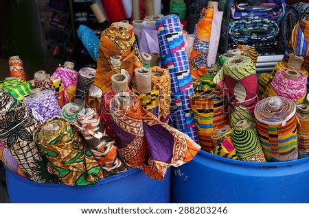 bins of colorful rolls of fabric outside a shop
